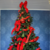 Large 2.9m green Christmas tree covered with traditional red and green decorations. 
Styled decorations include a red bow topper, red and green baubles and bells and large red bows and ribbon.  
Set up $190 | Hire $350 p/w | Removal $150 | Delivery TBC (depends on location)